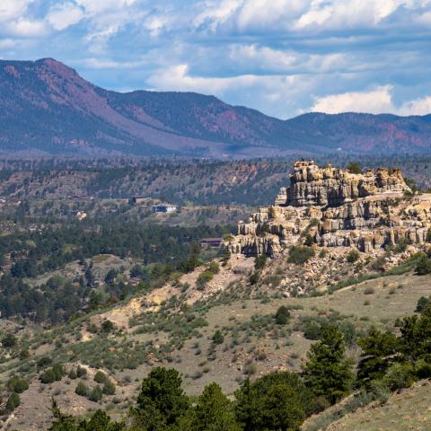 photo of a rock formation in front of a mountain range